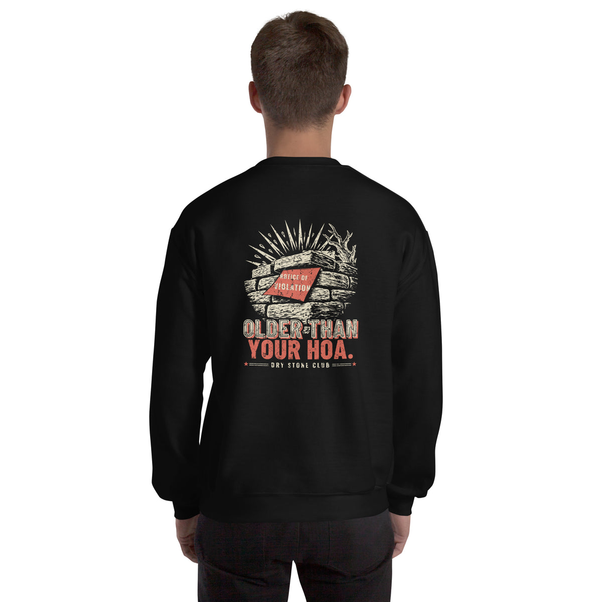 Man seen from behind wearing the black Older Than Your HOA sweatshirt, dry stone wall print across the upper back.
